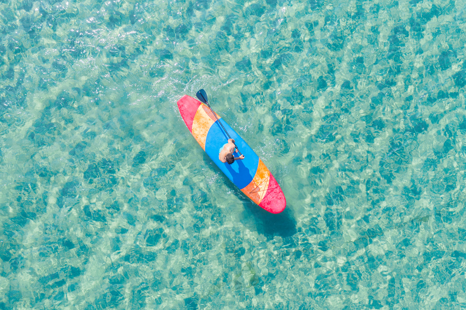 Teenage boy paddling with stand up paddle board